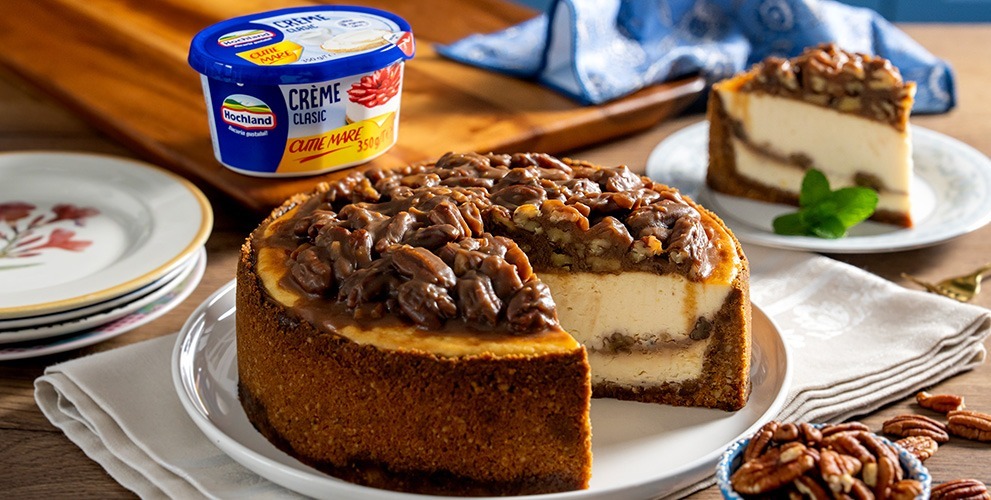 https://hochland.ro/wp-content/uploads/2025/10/Cheesecake-cu-nuci-pecan-_991x500.jpg